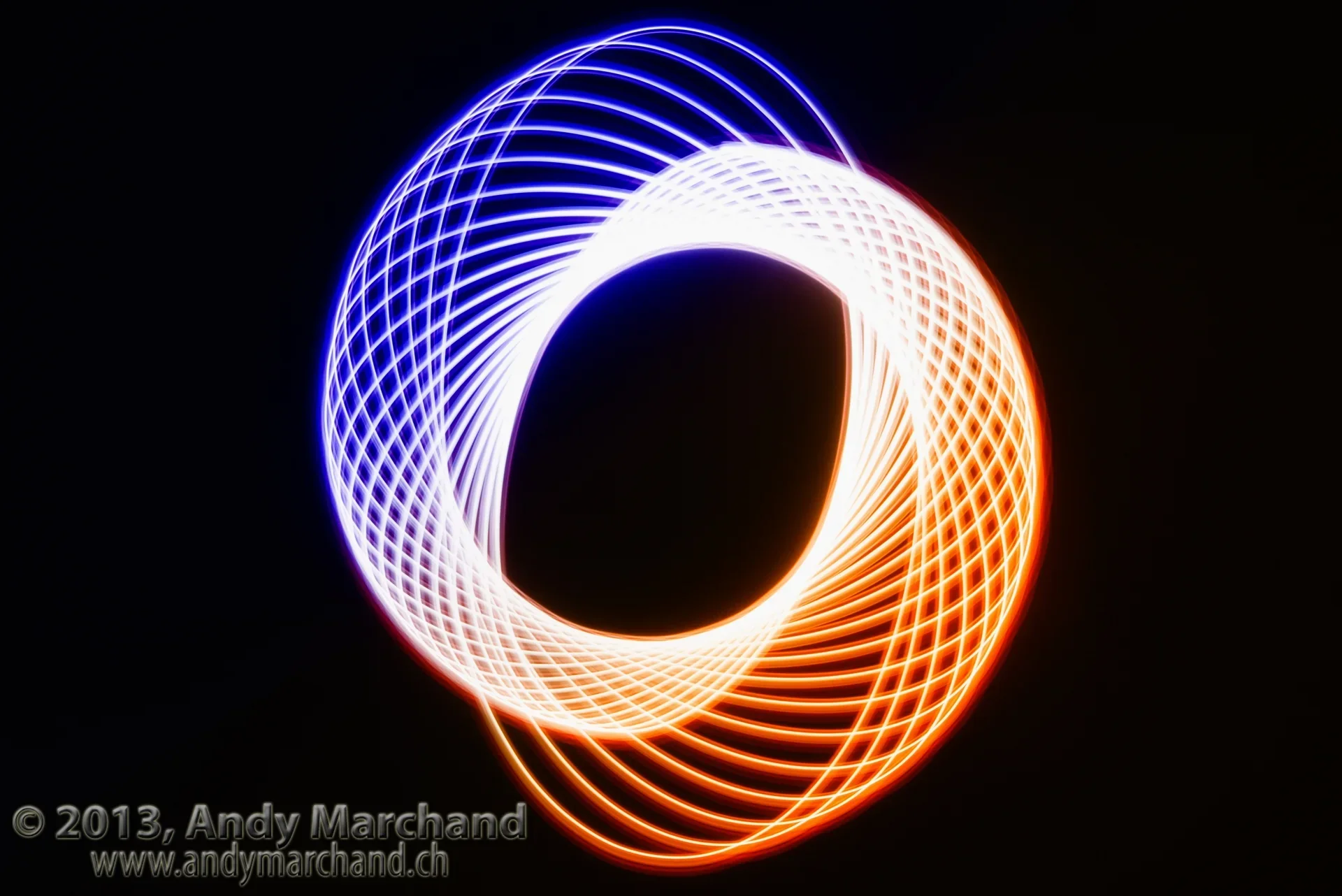 Blau-orange Lichtspuren bilden eine präzise geometrische Figur vor schwarzem Hintergrund
