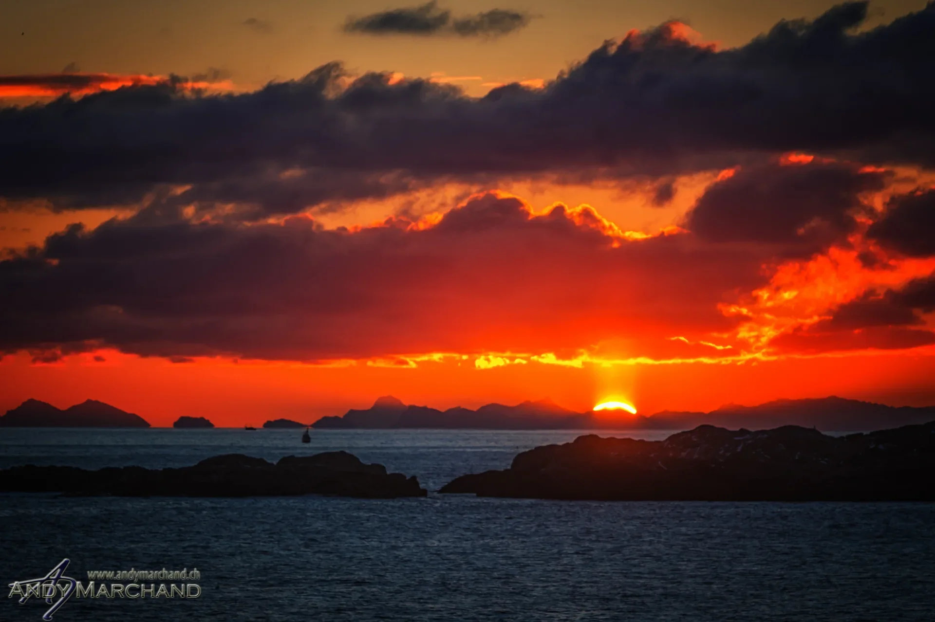 Oranger Sonnenuntergang über dem Meer und dunklen Inseln